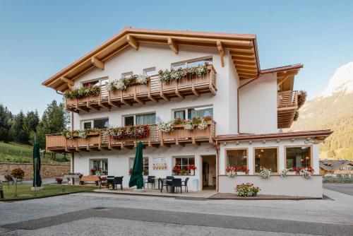 a hotel in the mountains with tables and chairs at Garnì Aurora Bed and Breakfast in Soraga