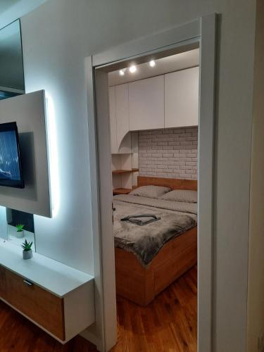 a small bedroom with a bed and a tv at Apartman Matija in Pale