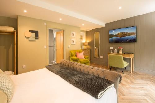 a bedroom with a large bed and a desk at Willowbeck Lodge Boutique Hotel in Carlisle