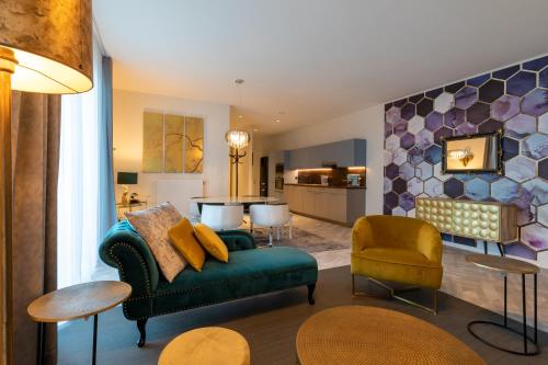 a living room with a green couch and a kitchen at GUILLEMINS STATION FLATS in Liège
