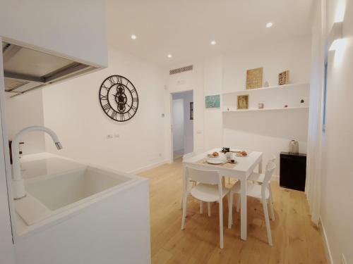 eine weiße Küche mit einem weißen Tisch und einem Waschbecken in der Unterkunft Casa Meltemi in Bari