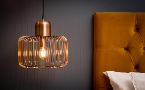 a hanging pendant light in a bedroom with a bed at Willowbeck Lodge Boutique Hotel in Carlisle