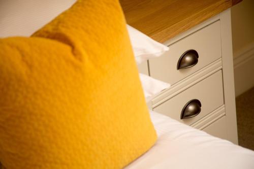 a close up of a bed with a yellow tie on it at Willowbeck Lodge Boutique Hotel in Carlisle