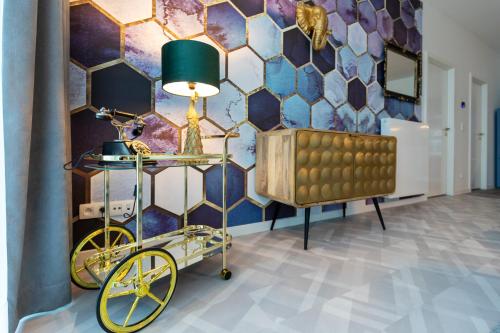 a room with a yellow cart and a mosaic wall at GUILLEMINS STATION FLATS in Liège
