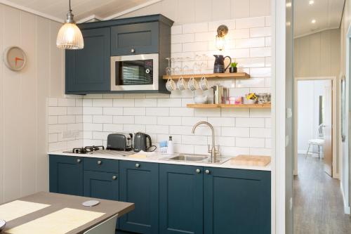 a kitchen with blue cabinets and a sink at Willowbeck Lodge Boutique Hotel in Carlisle