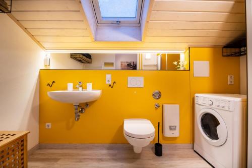 La salle de bains est pourvue d'un lavabo et d'un lave-linge. dans l'établissement Gemütliche Ferienwohnung mit Panoramablick, à Muttensweiler