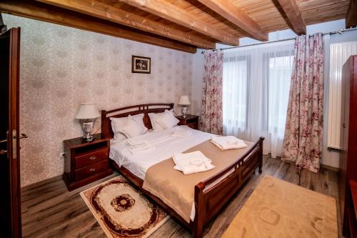 a bedroom with a bed with two towels on it at Villa Diva in Budureasa