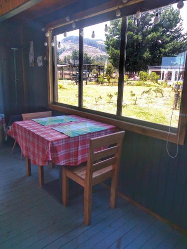 a table and chairs in a room with a window at Ecolodge Lanalhue Hostel in Cañete