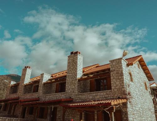 a building with a blue sky in the background at Mezonetes Helmos in Áno Lousoí