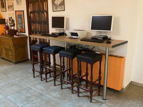 a desk with a computer and a bar with stools at Apparthotel Le Porto in Porto Ota