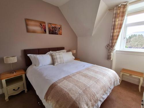 a bedroom with a large bed and a window at Atholl House Skye in Dunvegan