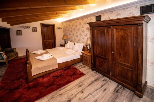 a bedroom with a bed and a wooden cabinet at Villa Diva in Budureasa
