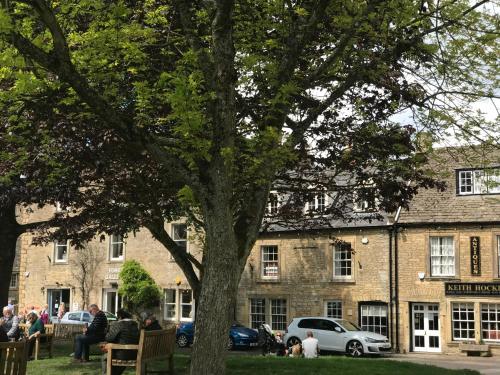 a tree in front of a large brick building at Lucy's Tearoom in Stow on the Wold