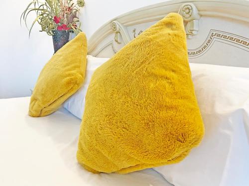 two yellow pillows sitting on top of a bed at The President Hotel in Blackpool