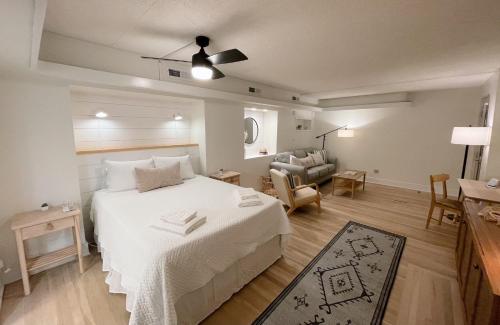 1 dormitorio con 1 cama blanca y sala de estar en Just Shy of the Bridge - Waterway Condo 110, en Wilmington