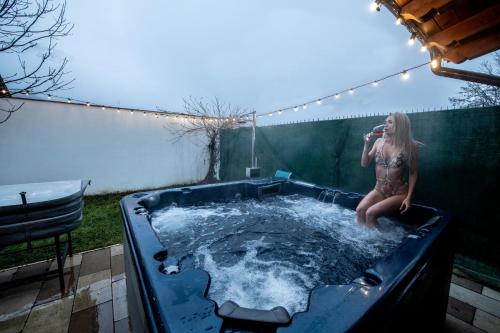 a woman is sitting in a hot tub at Villa Diva in Budureasa
