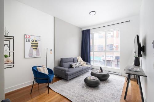 a living room with a couch and a blue chair at Hotel-Apart Prince Arthur in Montréal
