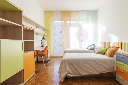a bedroom with two beds and a desk at La casa di Cri sul Naviglio in Milan