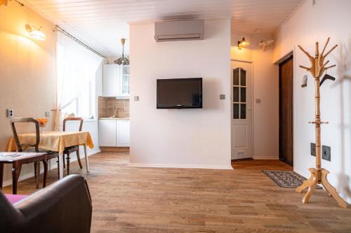 a living room with a table and a tv on a wall at Campenhausen lodging in the heart of Kuressaare in Kuressaare