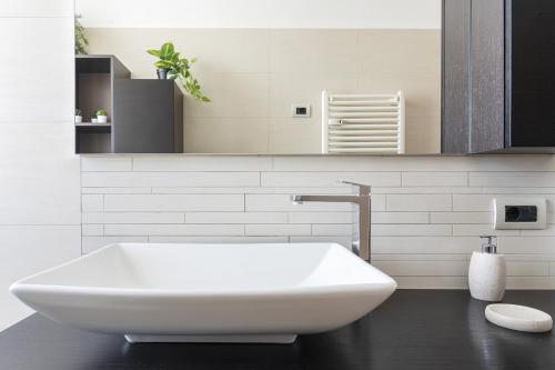 uma casa de banho branca com uma grande banheira branca em La casa di Cri sul Naviglio em Milão