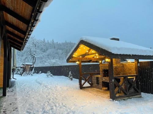a snow covered pavilion with lights on it at Mountain Residence in Tukhlya