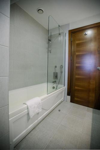 a bathroom with a tub and a glass shower at Baia Bursa Hotel in Bursa