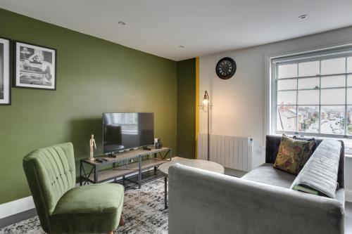 a living room with a couch and a tv at Cosy Chelmsford Apartment - Free Allocated Parking in Chelmsford