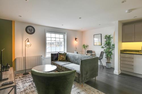 a living room with a couch and a table at Cosy Chelmsford Apartment - Free Allocated Parking in Chelmsford