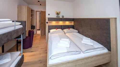 a bedroom with two beds with white sheets at Emma Deluxe Aparthotel ganzjährig beheizter Außenpool in Piesendorf