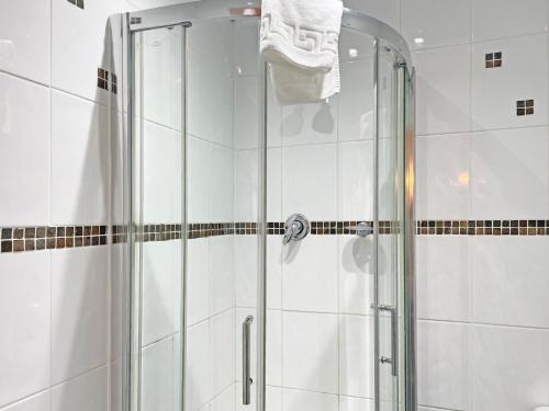 a bathroom with a shower with a glass door at The President Hotel in Blackpool