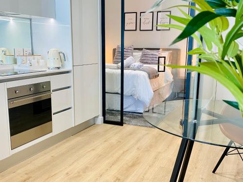 a bedroom with a bed and a glass table in a room at Waterfall Views From The Six- Luxurious Apartment in Midrand
