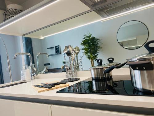 a kitchen with a stove with a pot on a counter at Waterfall Views From The Six- Luxurious Apartment in Midrand