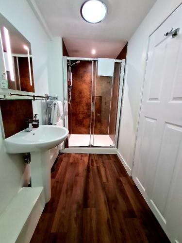 a bathroom with a white sink and a shower at Atholl House Skye in Dunvegan