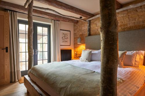 a bedroom with a large bed and a large window at Wild Thyme & Honey in Cirencester