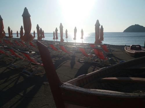 a group of umbrellas and chairs on a beach at Residence Sole in Albenga