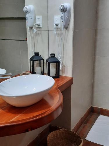 a bathroom with a sink and two lights on a counter at Luna de Cafayate Hotel Boutique in Cafayate