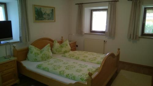a small bedroom with a bed and a television at Ferienwohnung Oberlechner in Anger
