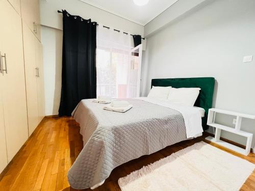 a bedroom with a bed with white sheets and a window at Acropolis Select Flat in Athens