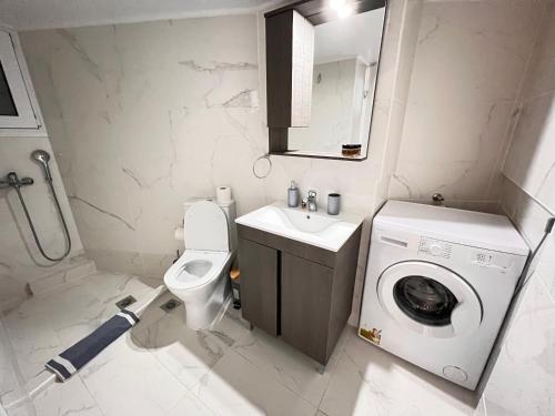 een kleine badkamer met een wasmachine en een wasmachine bij Acropolis Select Flat in Athene