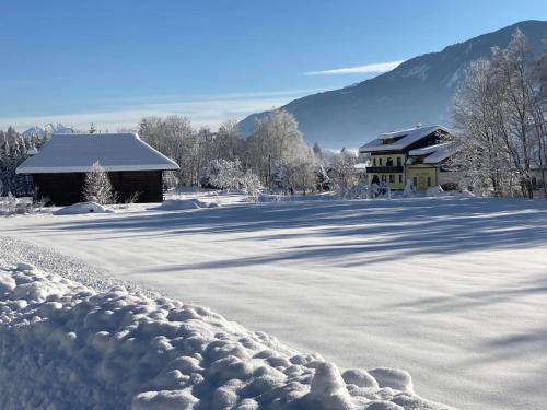 a snow covered yard with a house in the background at Loft Kammleitn in Hermagor