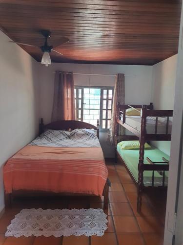 a bedroom with a bed and a ceiling fan at Leal house in Matinhos