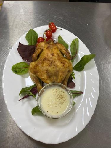 a white plate with a chicken with a dipping sauce at Montebello in Predeal