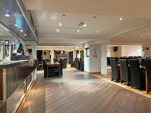 a restaurant with black chairs and a table and a bar at The President Hotel in Blackpool