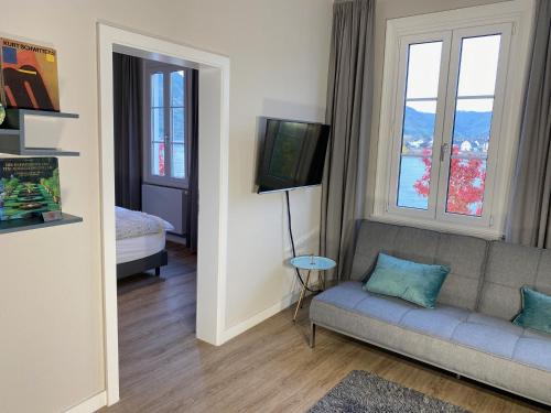 a living room with a couch and two windows at RHEIN-SUITES BOPPARD in Boppard