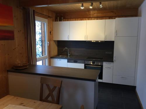 a kitchen with white cabinets and a black counter top at Alpenferienhaus Sophia in Sankt Lorenzen ob Murau