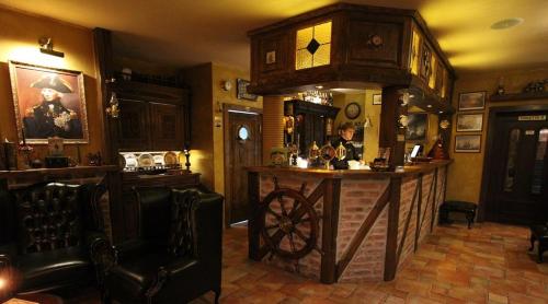 a bar in a pub with a clock on the wall at Hotel Starý Mlýn in Mlýnec