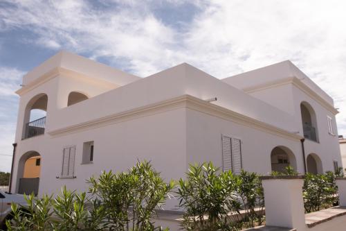 a white church with trees in front of it at Le Residenze del Golfo di Orosei in Orosei