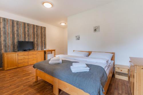 a bedroom with a bed with towels on it at Resort Pasecna in Přední Výtoň