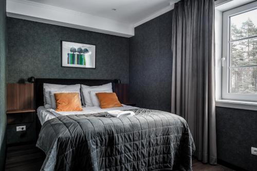 a bedroom with a bed with orange pillows and a window at Best Western Hotell Hedåsen in Sandviken