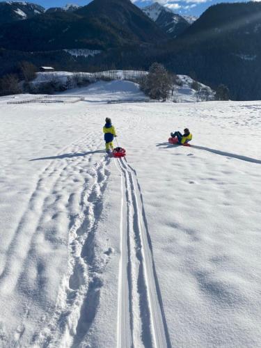 two people in the snow with tracks in the snow at B&B Pichler Casa in Castello di Fiemme